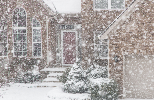 front view of a home during a snow storm.