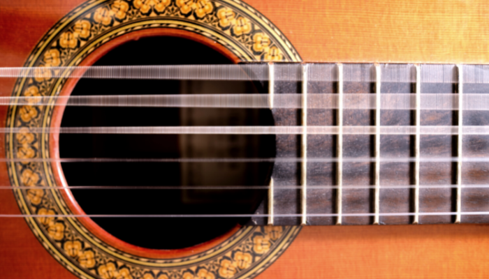 close up view of guitar strings vibrating.
