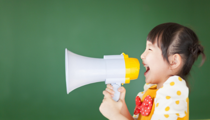 child talking loud into a megaphone.