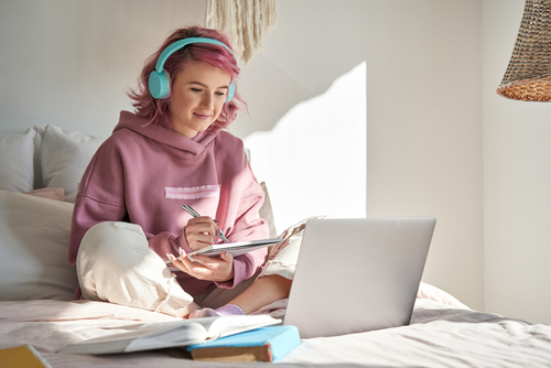 young woman on her computer with headphones on