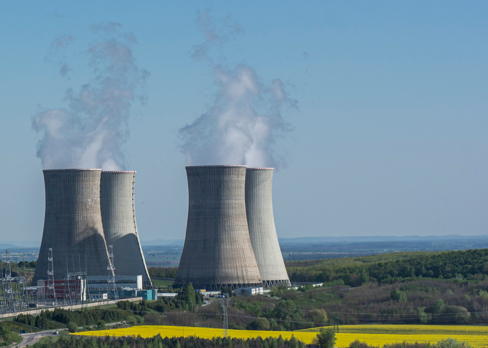 Cooling towers of nuclear power plant Mochovce with the yellow field of rapeseed in front of them.