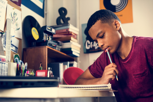 young man at a desk, writing