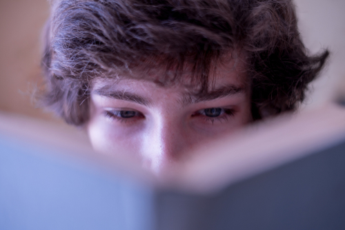 close up view of man's eyes looking in the book, careful readin