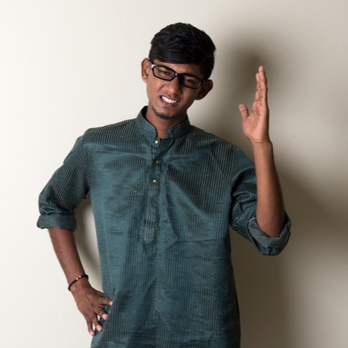 young man, arms raised, looking confused