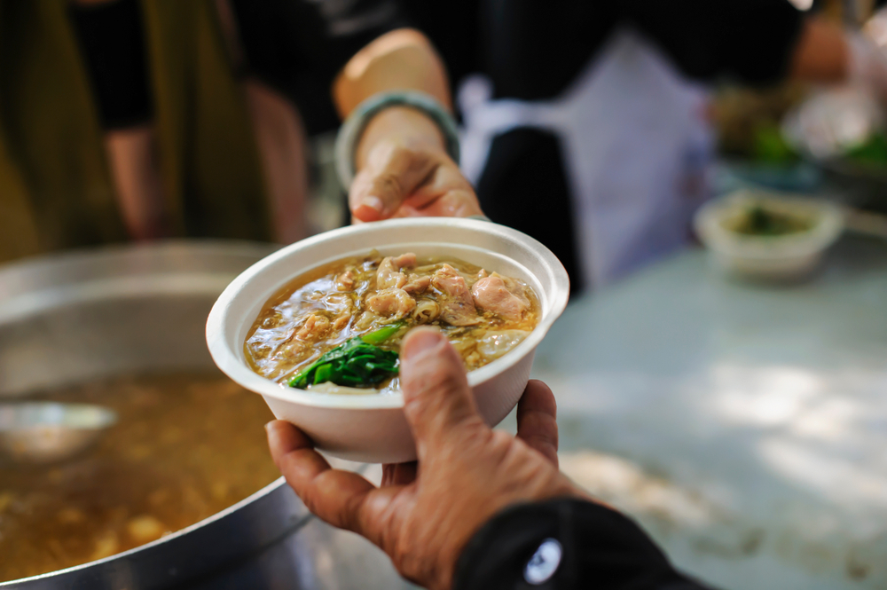 woman passing bowl of soup