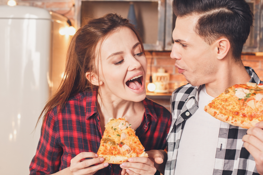 girl and boy eating pizza