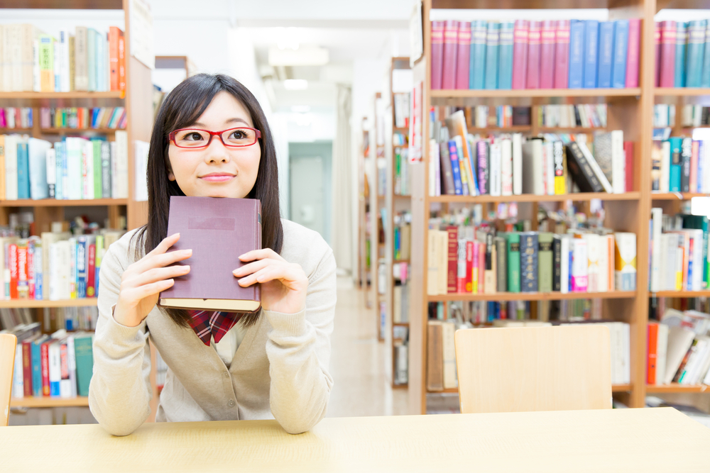 girl in library holding a book