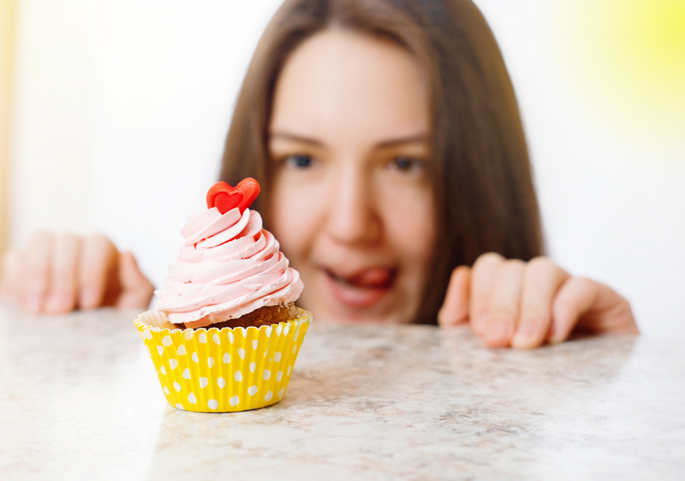 girl looking at cupcake