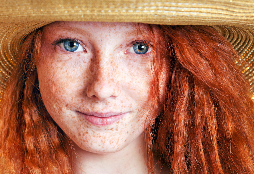 girl with red hair and blue eyes wearing a hat