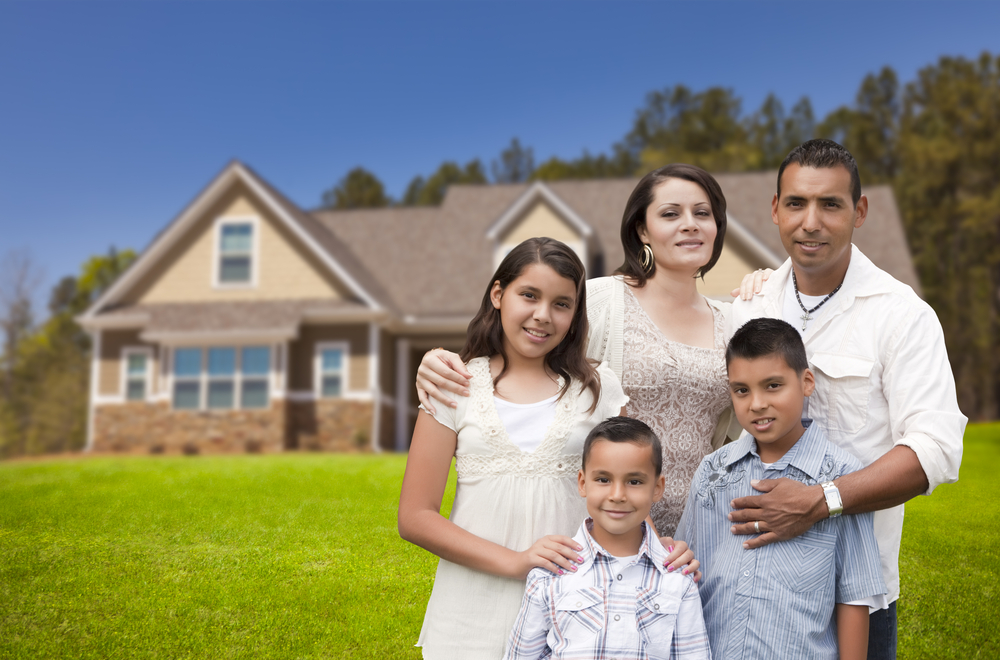 family of five in front of house