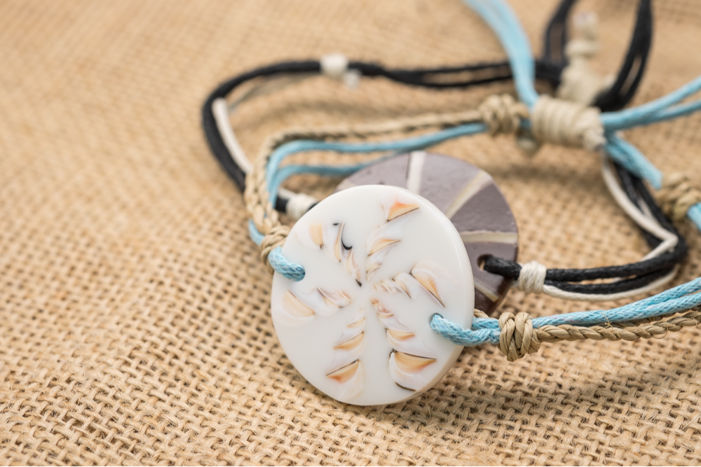 Round shape sea shell bracelet made of string with tan burlap background