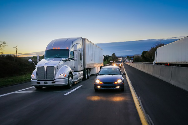 tractor-trailer and car on a highway