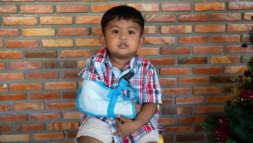 young boy, with his arm in a sling