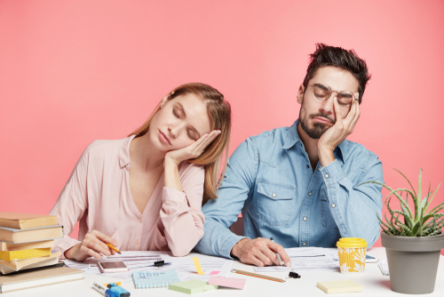 man and woman falling asleep at a table