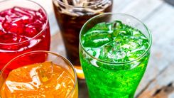 O refrigerante é um exemplo de produto que contém corantes. Copos com refrigerantes coloridos.