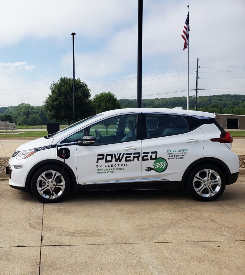 White Chevy Bolt with Powered By Electric, Iowa Lakes Electric Cooperative logo