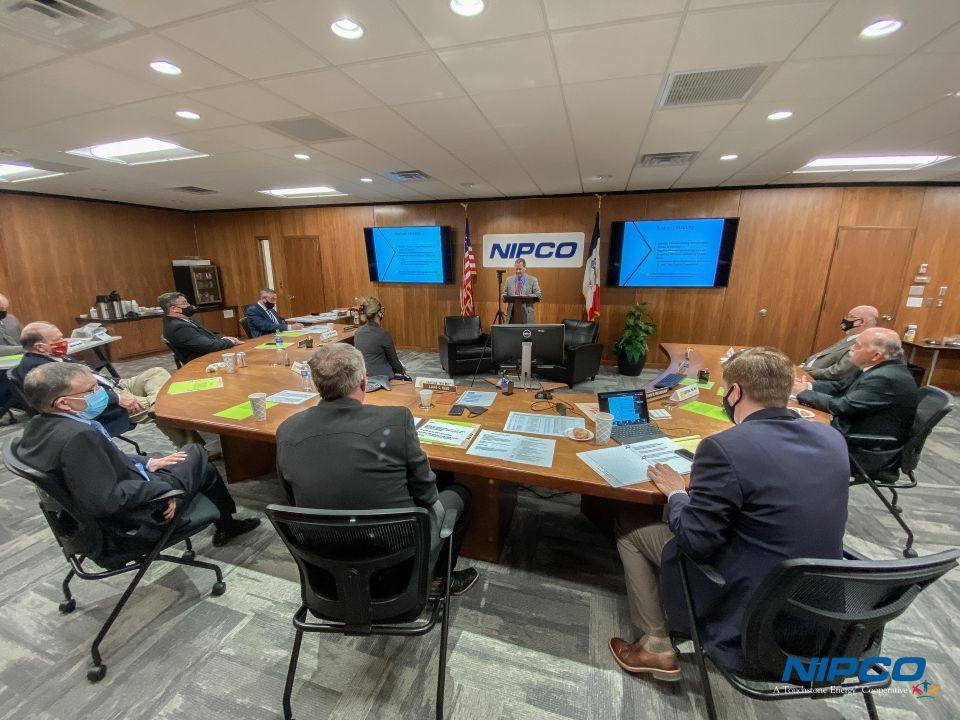 Photo of NIPCO staff and directors sitting at the board table, participating in the meeting.