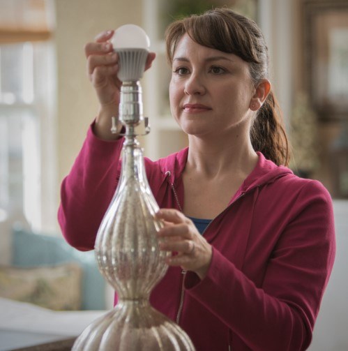 Photo of woman changing a light bulb