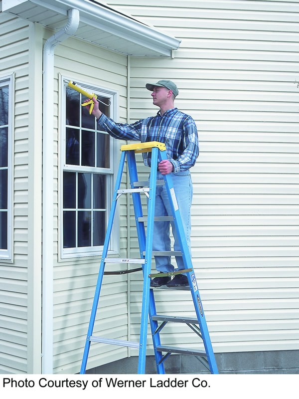 man on ladder caulking