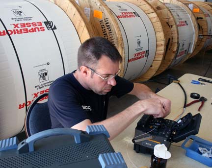 A NIPCO employee is pictured here splicing fiber optic cable.