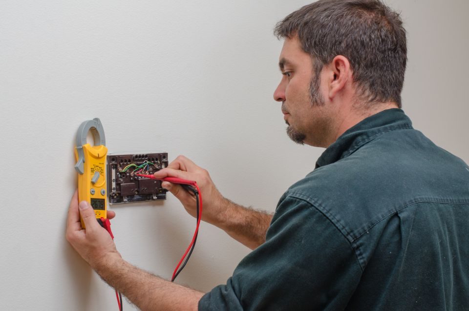 technician checking a thermostat