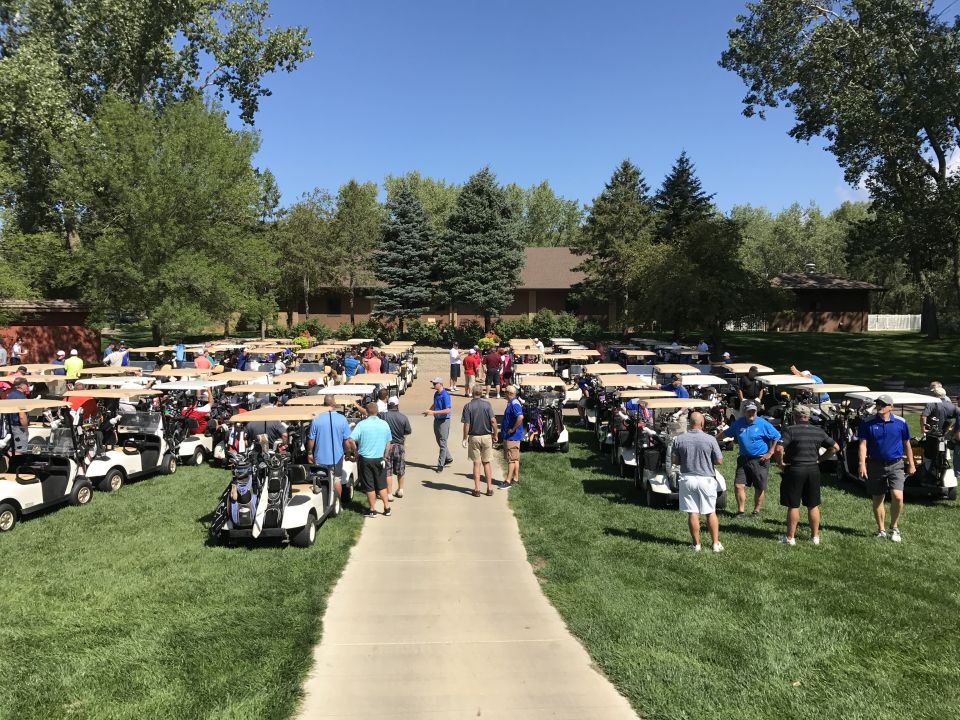 Golfers gather near their carts on the course at the starting point of the golf tournamnet