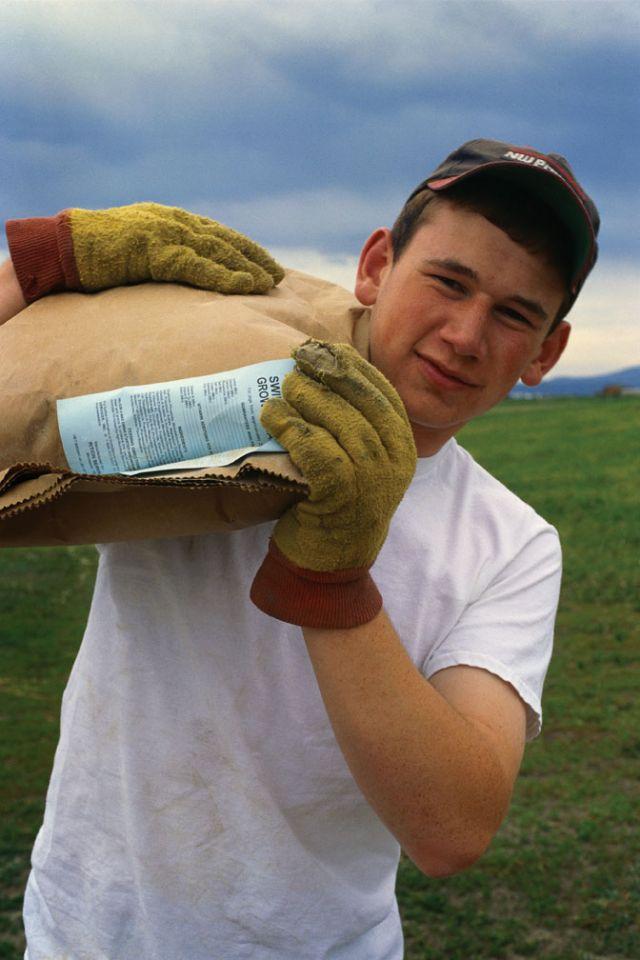 Young man with a bag of corn hoisted over his shoulder