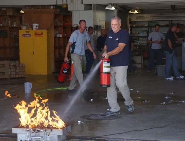 Photo of NIPCO employee performing fire extinguisher training.