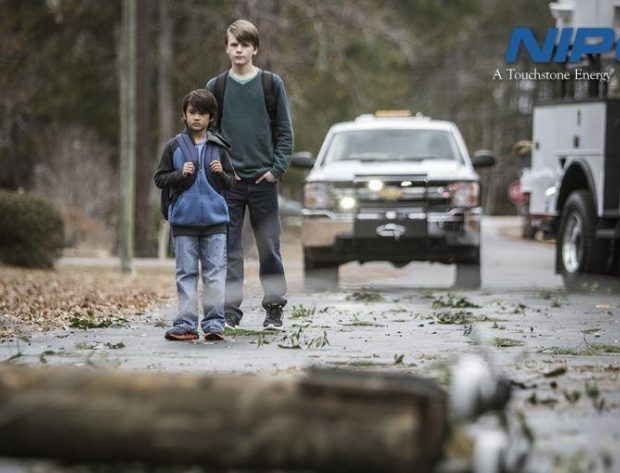 Two kids walking spot a downed power line and stop.