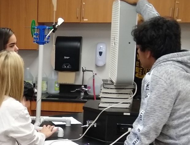 Students studying a model wind turbine in thier classroom