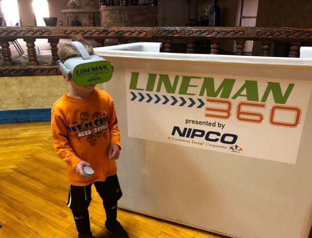 A young boy experiences Lineman 360 by wearing virtual reality goggles