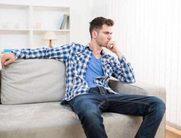 Photo image of a young man sitting on a couch
