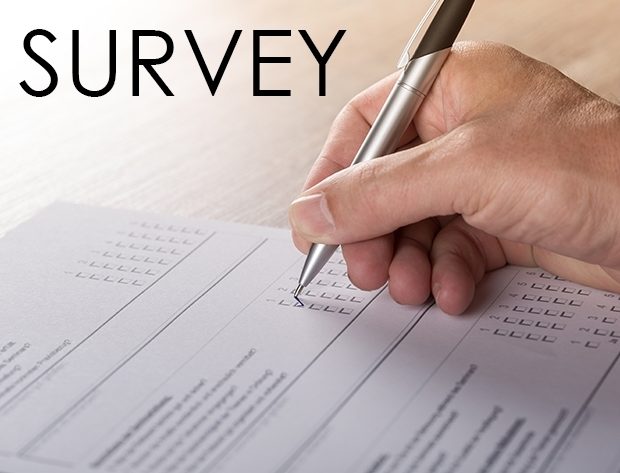 Close-up photo of a hand, holding a pen taking a survey