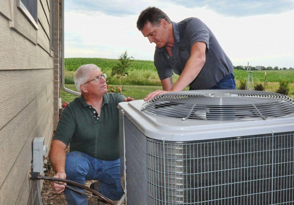 2 men working on an air-source heat pump