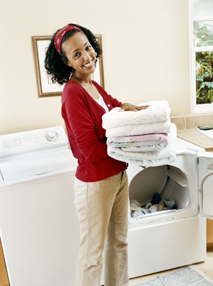 woman folding clothes from a dryer