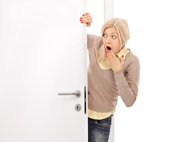 woman looking around a door with a surprised look