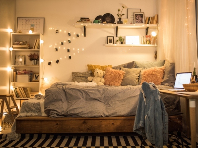Photo image of an empty bedroom with lights left on.