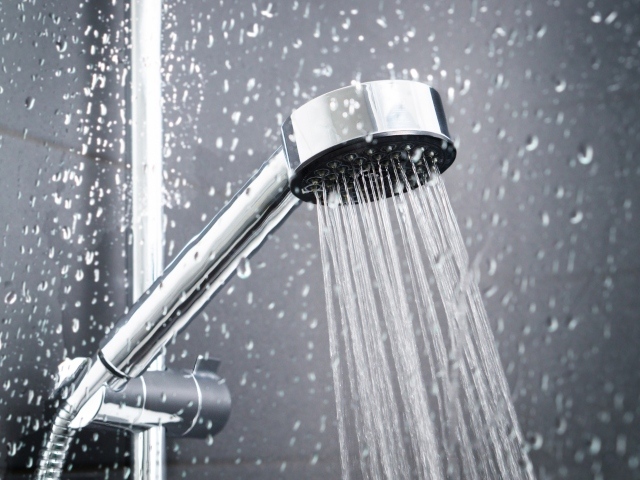 Photo image of a shower head with water running.