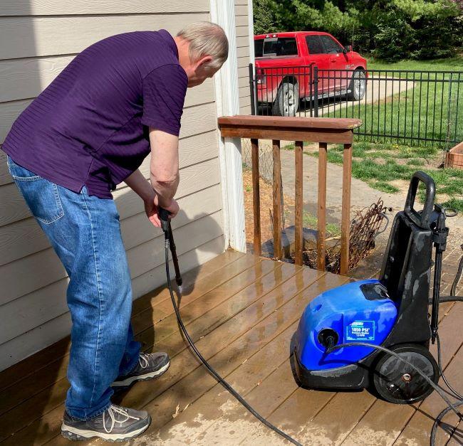 man using power washer