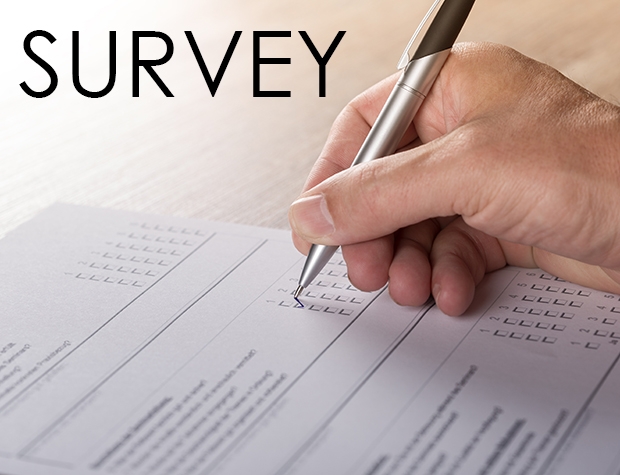 Close-up photo of a hand, holding a pen taking a survey