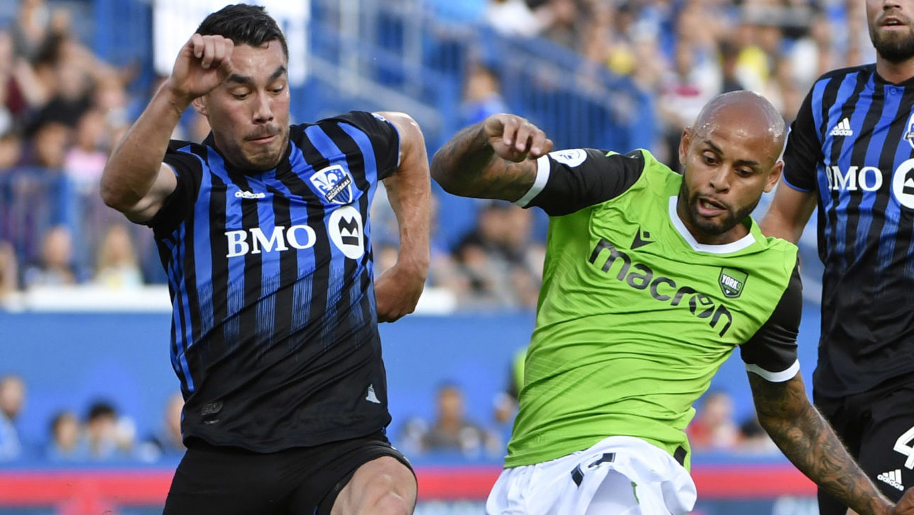 Jul 24, 2019; Montreal, Quebec, Canada; York9 FC defender Kyle Porter (19) battles the ball with Montreal Impact defender Daniel Lovitz (3) and Montreal Impact Rudy Camacho (4) during the first half at Saputo Stadium. Mandatory Credit: Eric Bolte-USA TODAY Sports