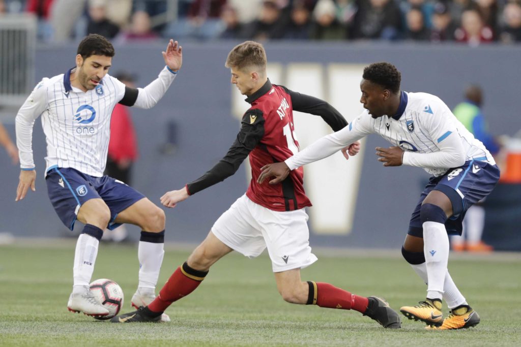 May 4, 2019; Winnipeg, Manitoba, CAN; Valour FC attacker Tyler Attardo (16) splits between FC Edmonton defender Ramón Soria (5) and FC Edmonton defender Mélé Temguia (8) in the second half during a Canadian Premier League soccer match at Investors Group Field. Mandatory Credit: James Carey Lauder-USA TODAY Sports for CPL