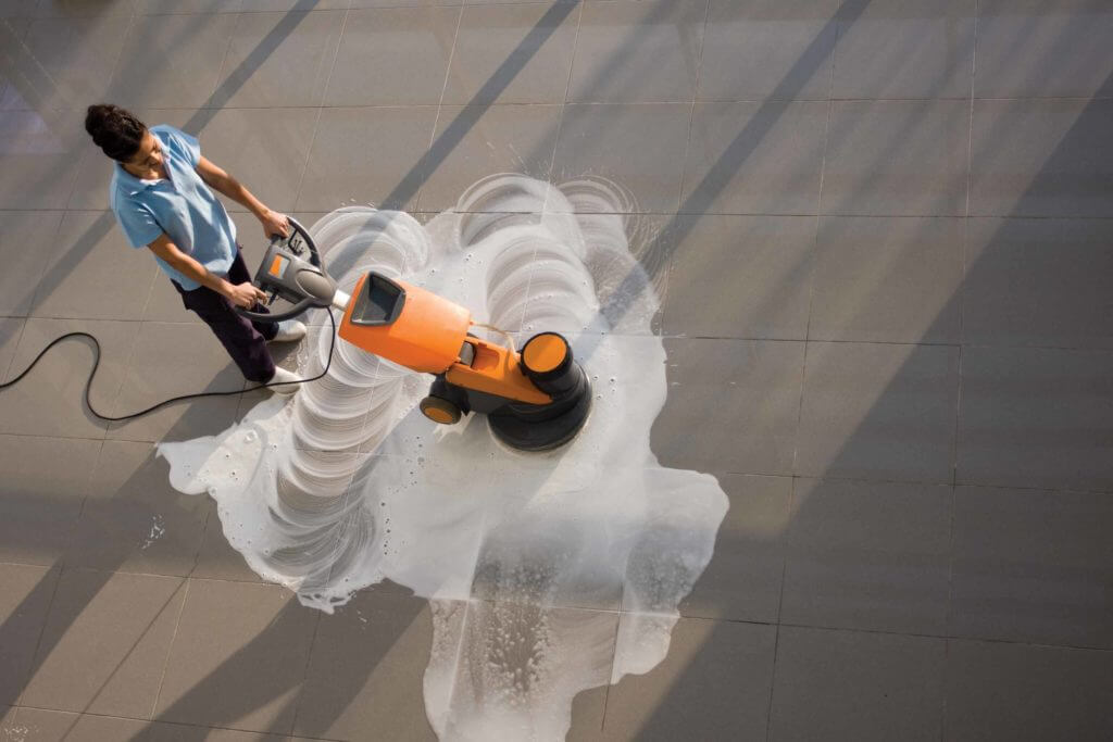 worker is cleaning the floor with machine