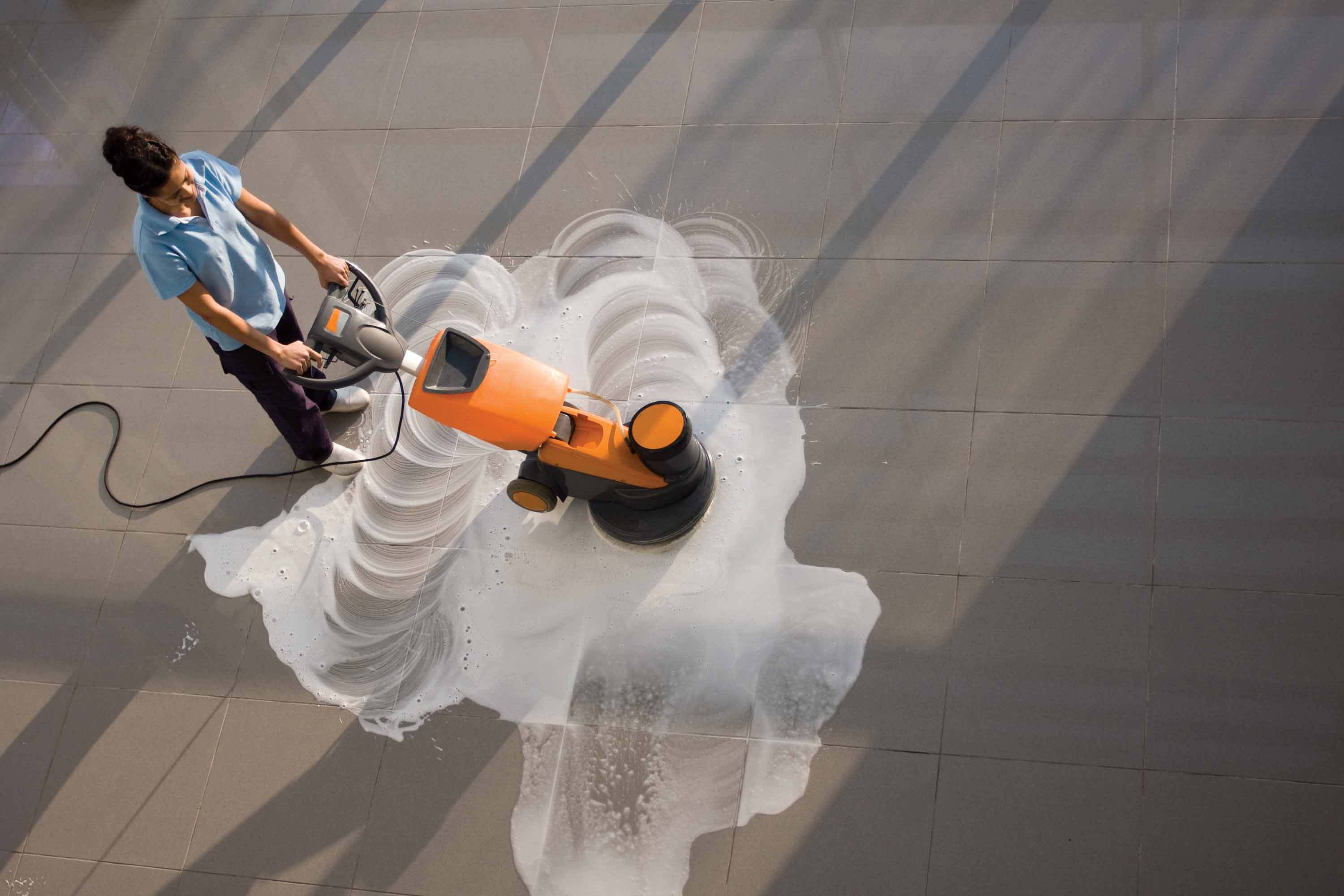 worker is cleaning the floor with machine