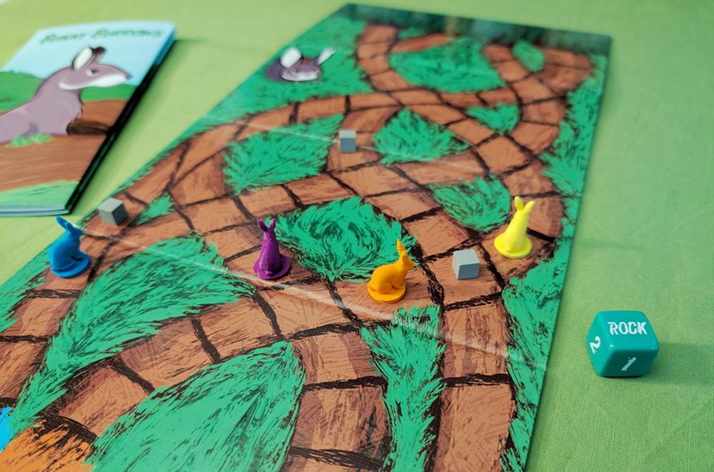 Gameplay photo showing the board, custom dice, and rabbits and rocks on the board