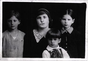 Black and white photograph from the 1930's of Elie Wiesel (front, age 4?) with his two older sisters and their mother.