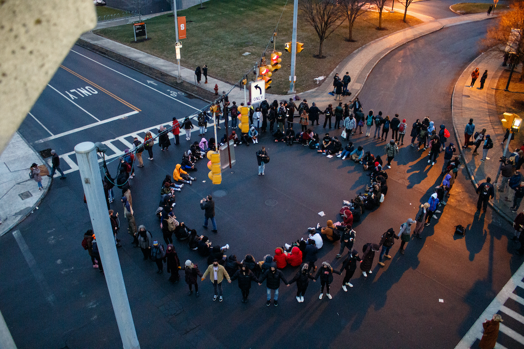 Students sitting in a circle in the intersection outside crouse-hinds