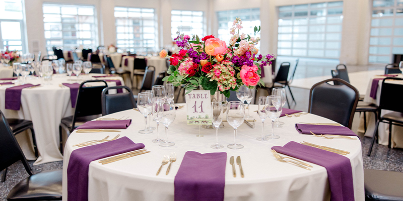 purple and white table arrangement in the oaks terrace room
