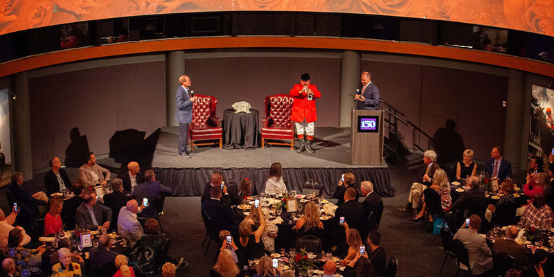 bugler on stage at an event in the great hall