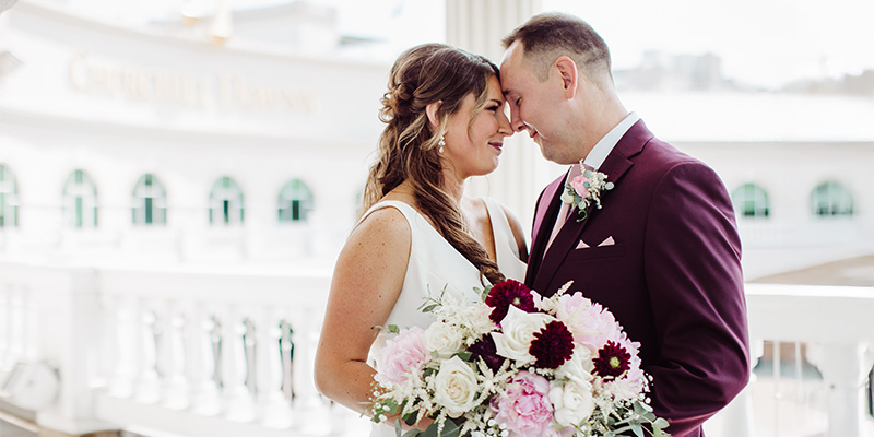 couple holding a bouquet of flowers together on the 2nd floor gallery balcony